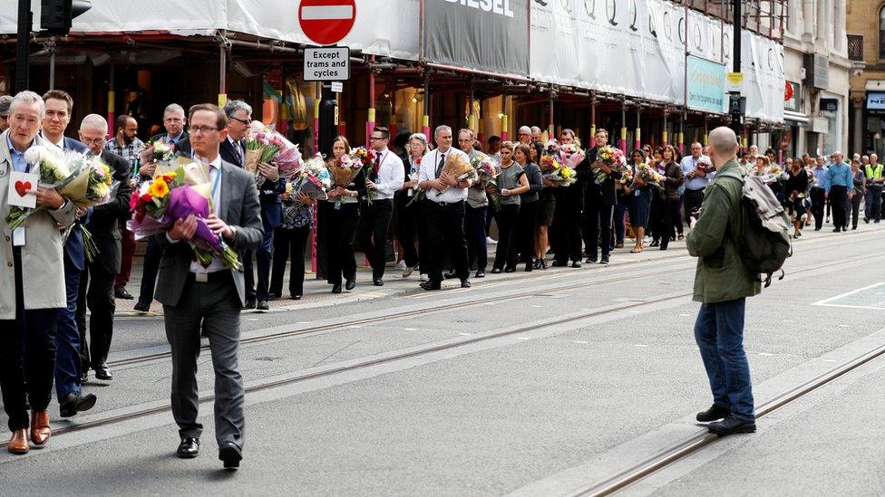 City council employees move flowers from the town hall in Albert Square to St Ann's Square in Manchester