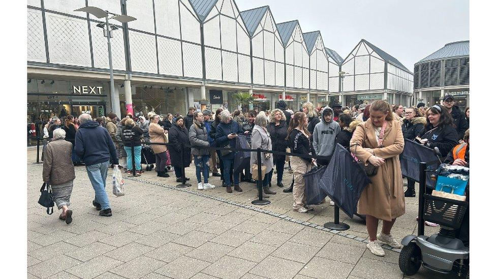 Shoppers queuing to get into a Primark store