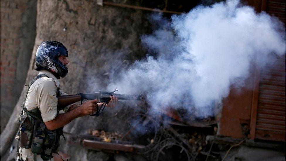 An Indian policeman fires a teargas shell towards demonstrators during a protest against the recent killings in Kashmir, in Srinagar on 23 September 2016.