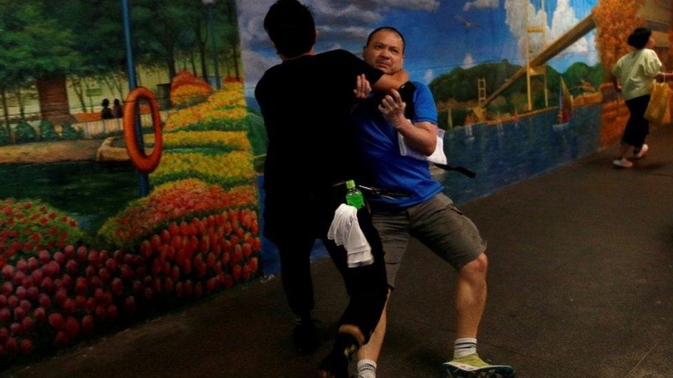 A pro-government supporter is attacked by an anti-extradition supporter outside the office of Junius Ho in July