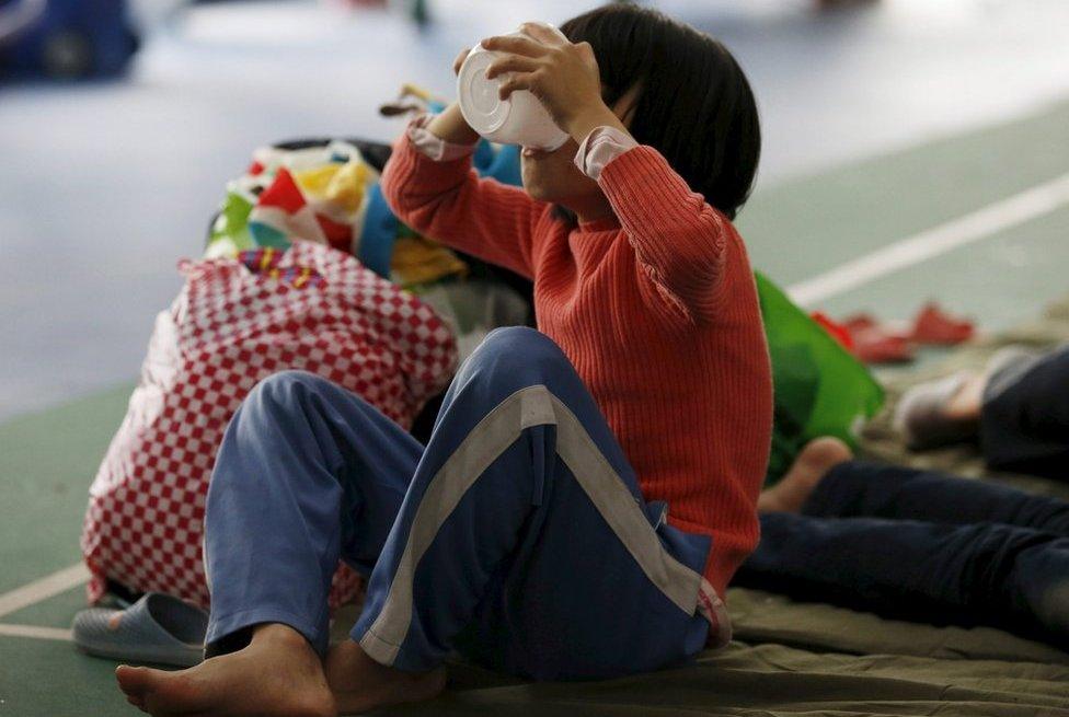 An evacuee girl eats food in a shelter set up at a gymnasium near the industrial park hit by a landslide in Shenzhen, Guangdong province, 22 December 2015