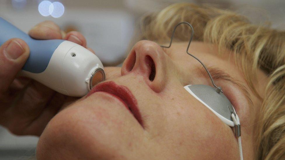 Close up of woman's face as mole is removed