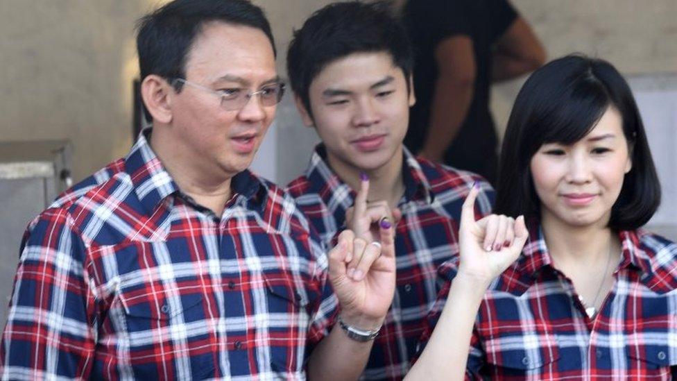 Basuki Tjahaja Purnama (L) with his son and wife vote in Jakarta (16 Feb 2017)