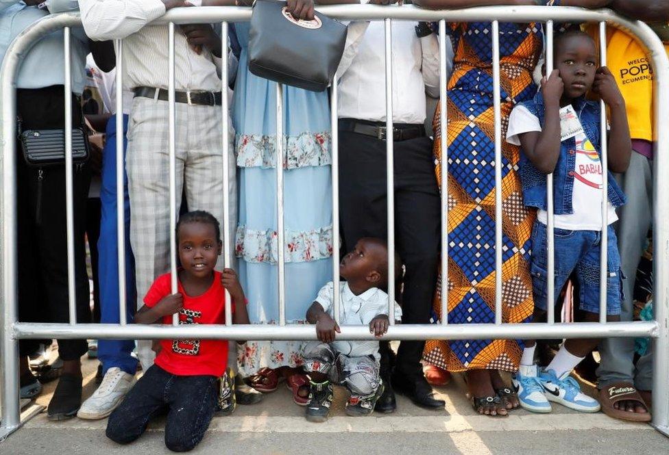 Children wait for the arrival of the Pope