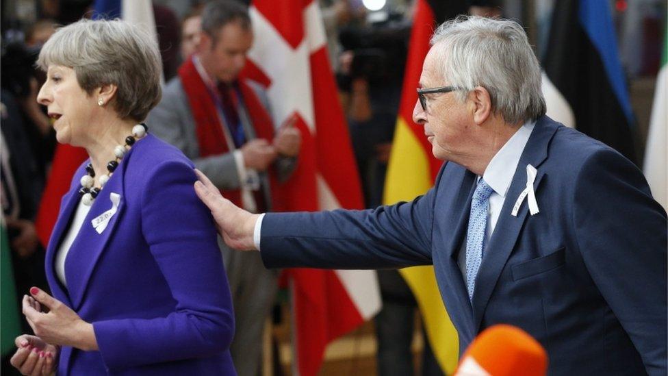 Jean-Claude Juncker taps Theresa May on the shoulder at press conference