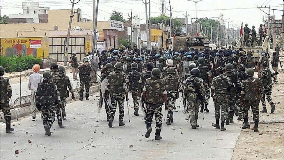 Indian paramilitary personnel walk towards the "Dera Sacha Sauda" Ashram in Sirsa on August 26, 2017, after followers of controversial guru Ram Rahim Singh on August 25 went on a rampage after their spiritual leader was convicted of rape.