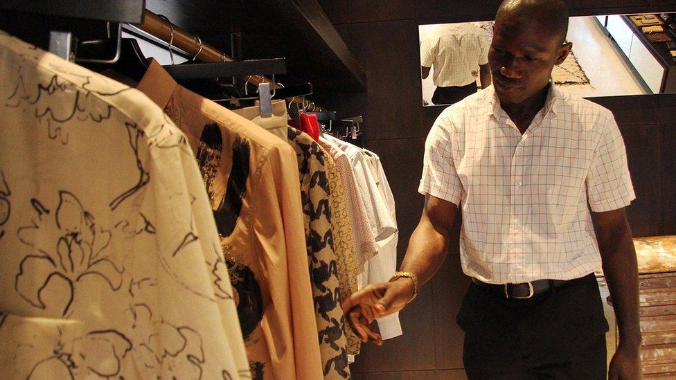 A man looks at clothes in a shop in Lagos, Nigeria