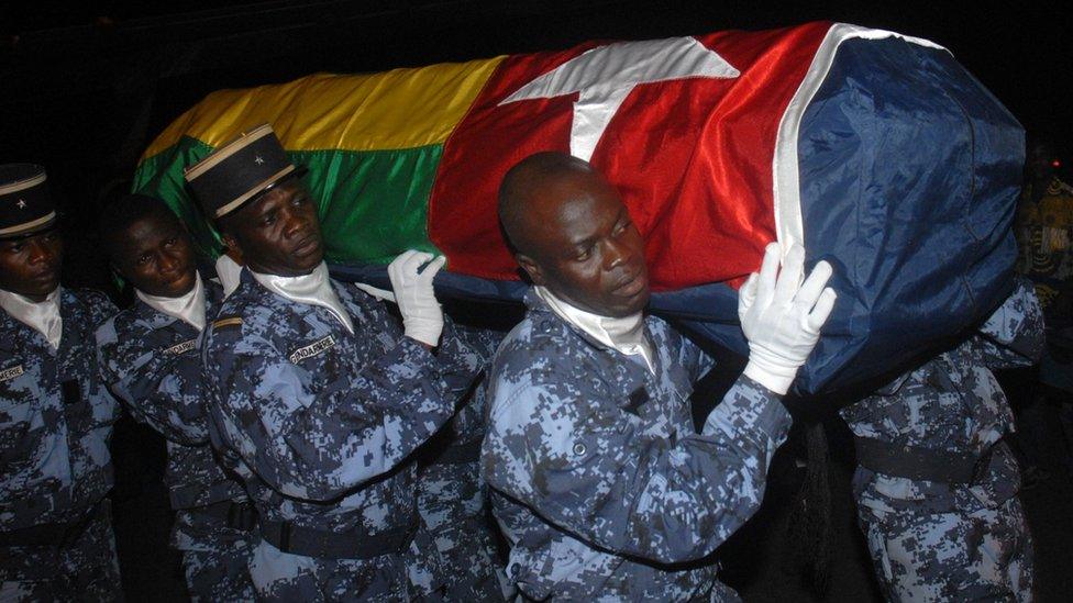 Togolese gendarmes carry the coffin wrapped in the national flag of one of the victims of the rebel attack that killed two of members of the Togolese national football team on 9 January 2010 after the team's arrival at Lome airport on 11 January 2010.