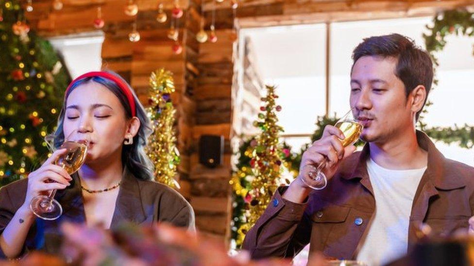 People enjoying a glass of wine at a Christmas party