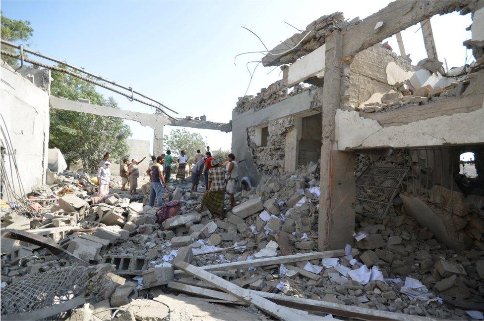 People stand on the rubble of a prison struck by Arab coalition warplanes in al-Zaydiyah district of the Red Sea port city of Hodeidah, Yemen October 30, 2016.