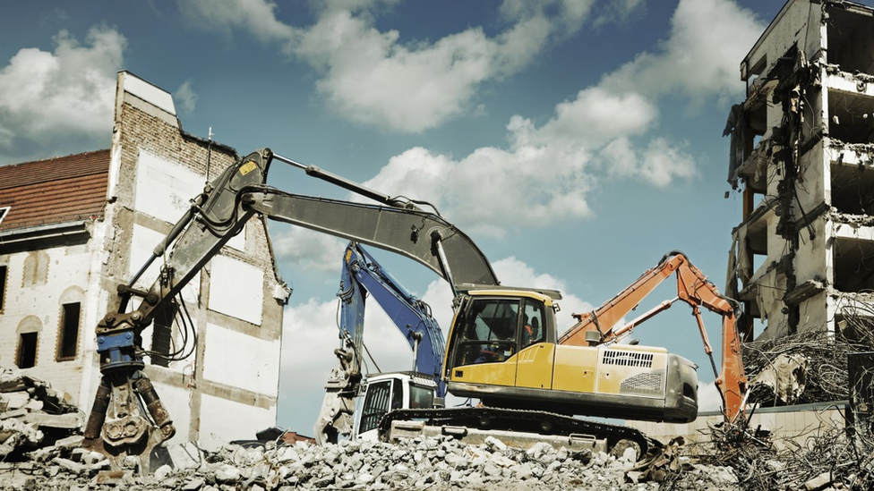 Bulldozers destroying old houses