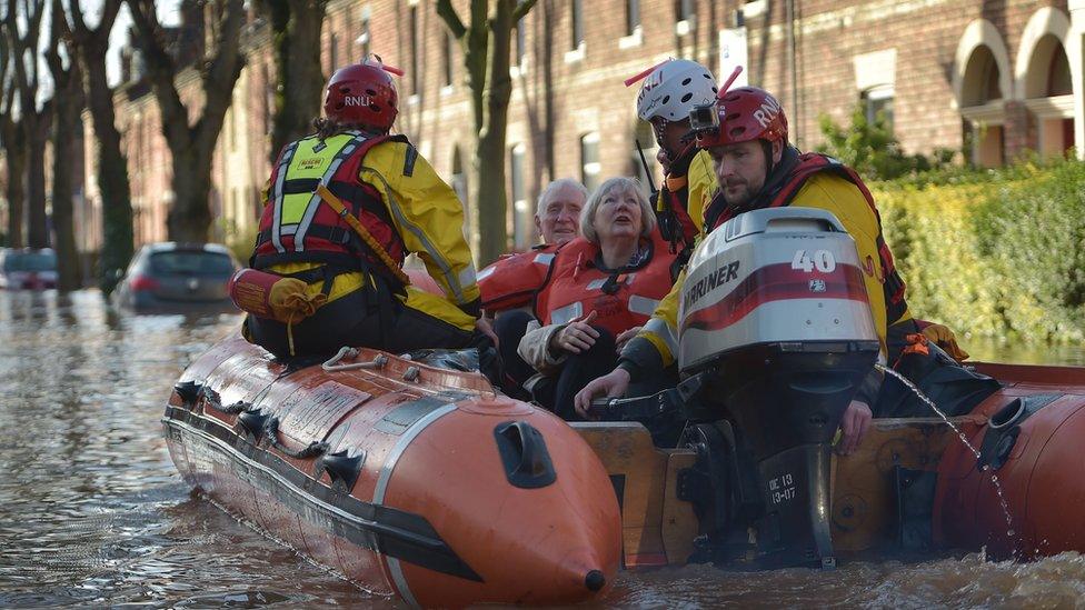 A rescue team helps to evacuate people from their homes on Sunday, after Storm Desmond caused flooding in Carlisle