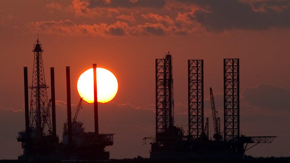 Oil rigs under construction at sunset