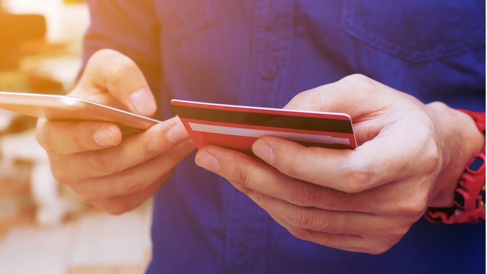 young man paying for something on a smart phone