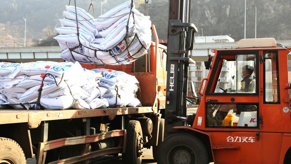 Workers load bags of potassium chloride from Canada