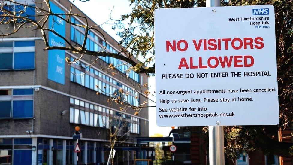 Sign saying no visitors allowed outside hospital