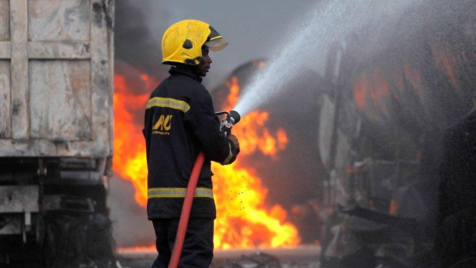 A firefighter sprays water to extinguish a fire at the site of an accident after multiple fuel tankers spilled their cargo on a bridge along Lagos-Ibadan expressway in Lagos, Nigeria, 21 June 2020