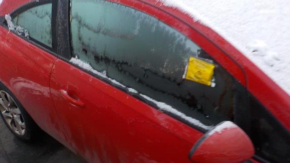 Oliver Claxton's car covered in snow with a parking ticket