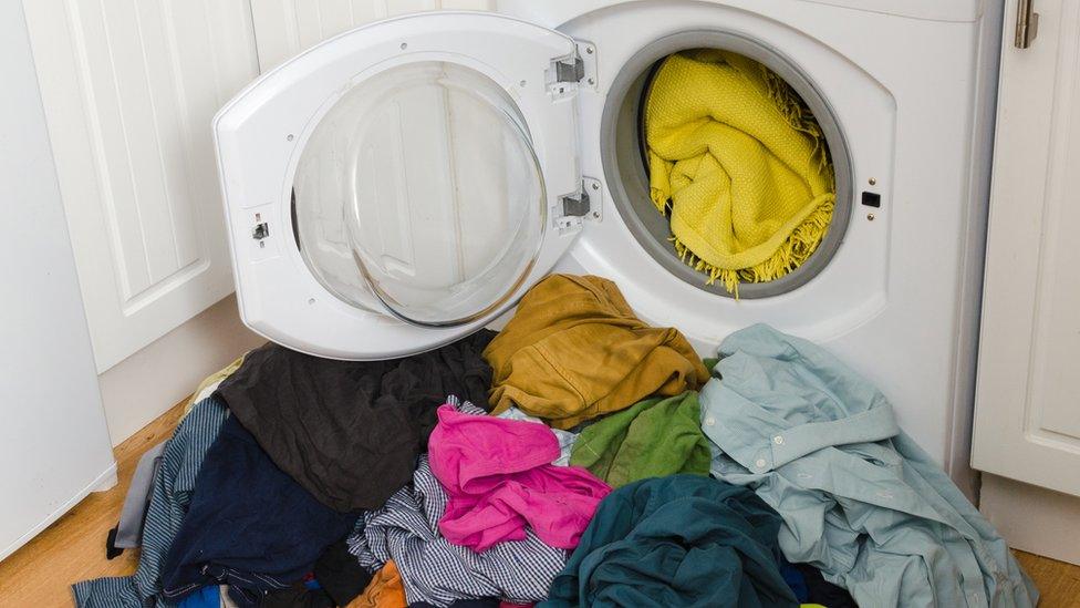 Clothes spilling out of a washing machine