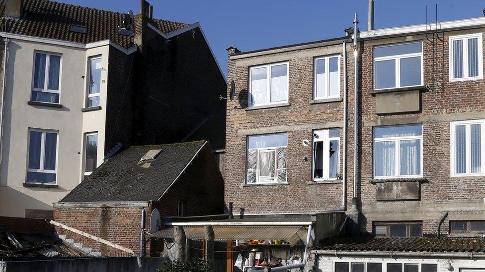 Broken window at the back of apartment raided by police in Forest