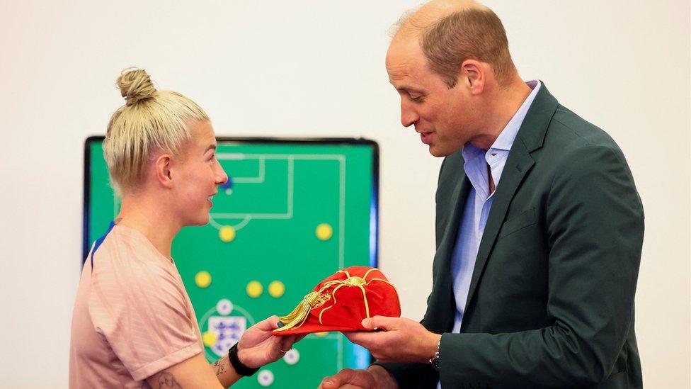 The Prince of Wales presents a legacy cap to Bethany England, during a visit