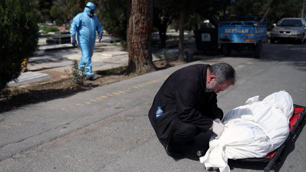 A man mourns the journalist Abdollah Zavieh, who died as a result of Covid-19, at Behesht Zahra cemetery in Tehran, Iran (24 March 2020)