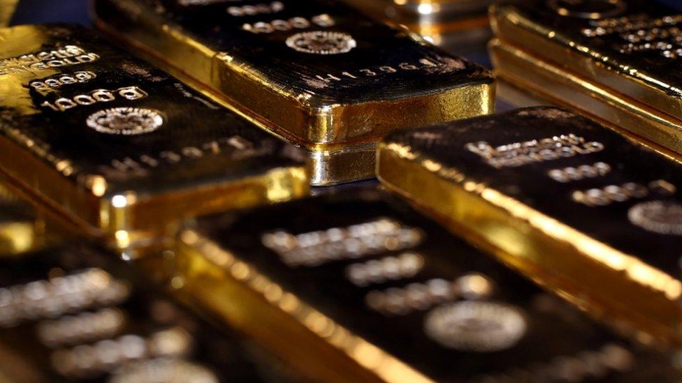 Gold bars stacked in a safe deposit box room.