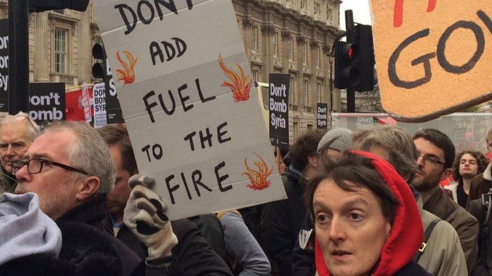 Protester waves banner reading: "Don't add fuel to the fire"