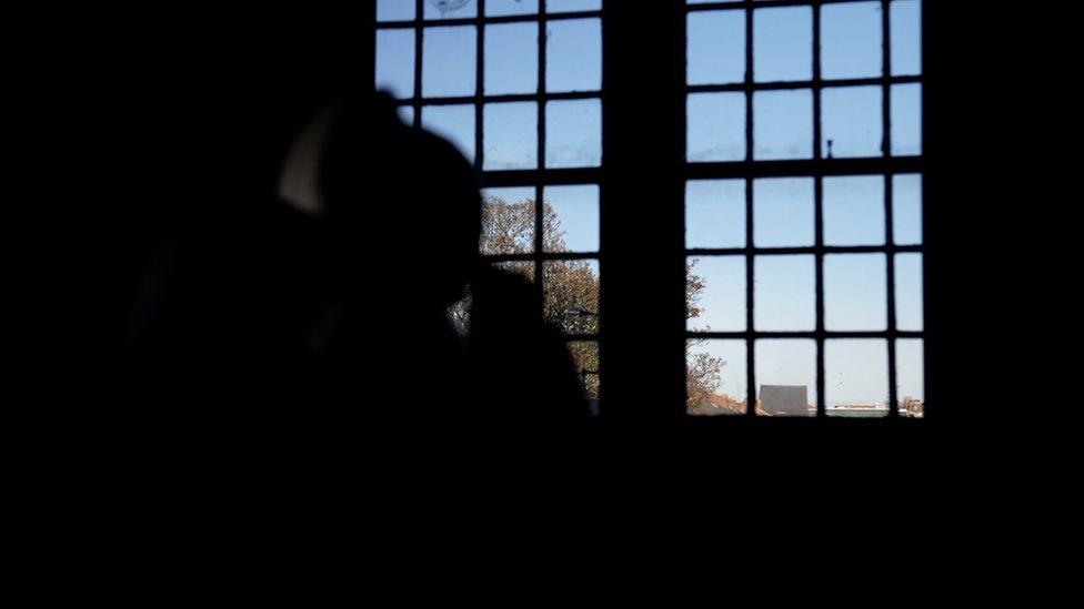 A woman sitting by her window