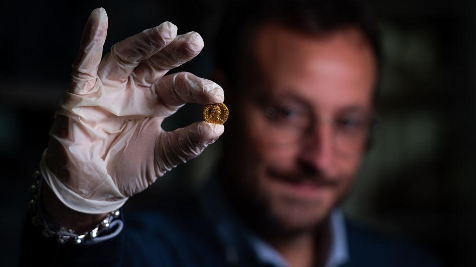 Alessandro Russo, archaeologist, and gold coin found with the female skeleton