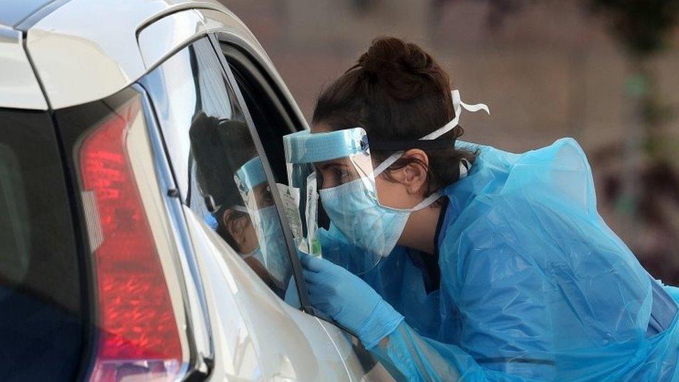 A nurse prepares to take a sample at a COVID 19 testing centre in the car park of the Bowhouse Community Centre in Grangemout