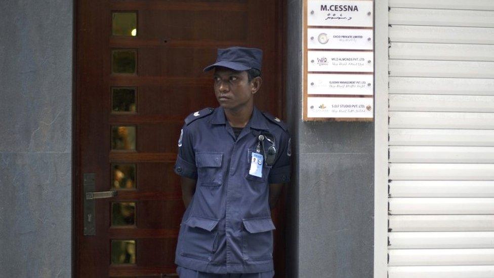 A Maldives police officer stands guard outside the residence of former Vice President Mohamed Jameel in Male (24 October 2015)