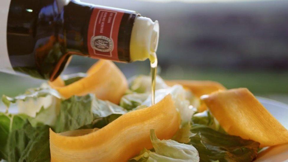 Olive oil being poured over salad