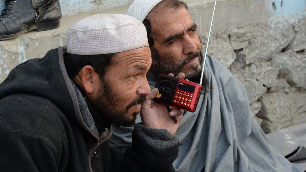 In this photograph taken on December 22, 2015, Afghan men listen to a radio broadcast run by the Islamic State group in Jalalabad