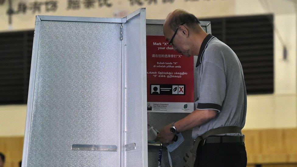 A Singaporean man casts his vote at a polling station in Singapore on 11 September 2015