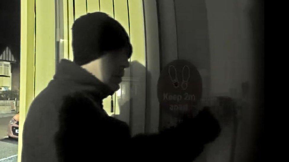 CCTV footage of man tampering with door lock