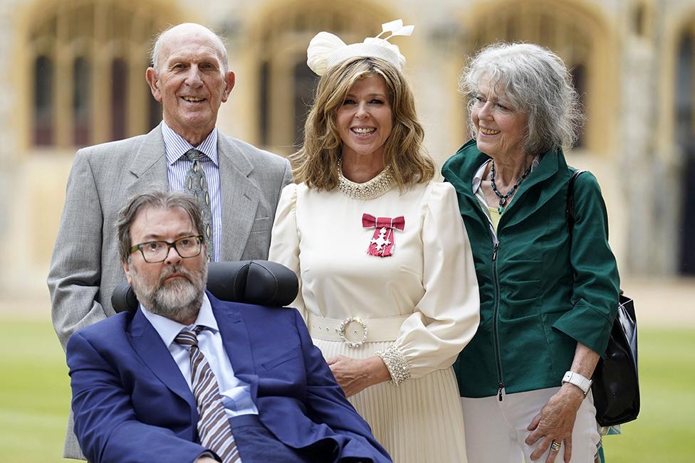 Kate Garraway stands with her husband Derek Draper and her parents Gordon and Marilyn Garraway, after being appointed a Member of the Order of the British Empire (MBE)