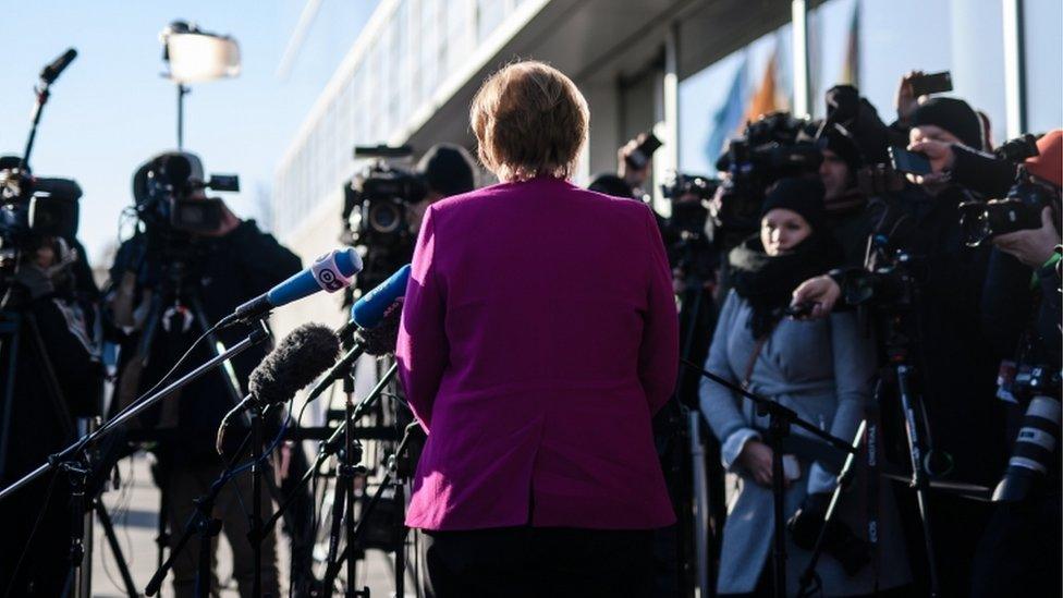 Back view of Angela Merkel facing the waiting press on 6 Feb