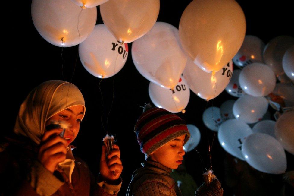 Children carry balloons before releasing them towards Damascus from the rebel-held suburb of Jobar, 30 December