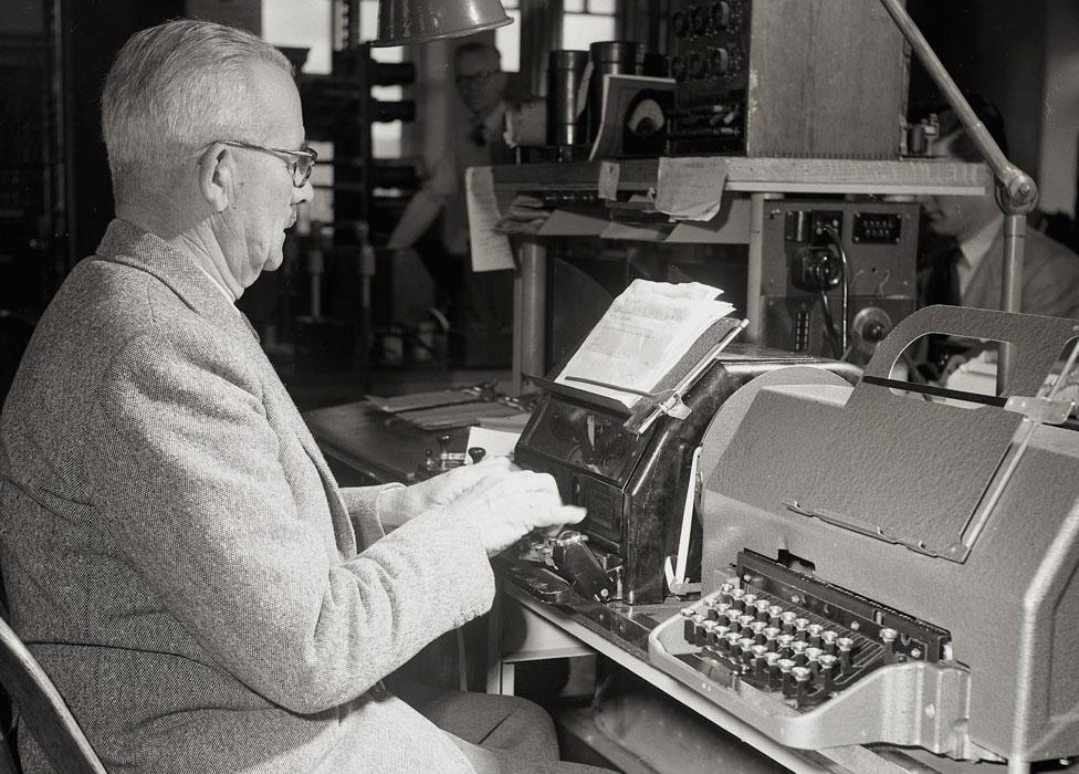 A man sends a telex message in the 1950s