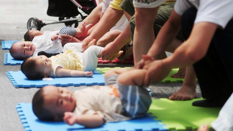 Three babies lying on mats