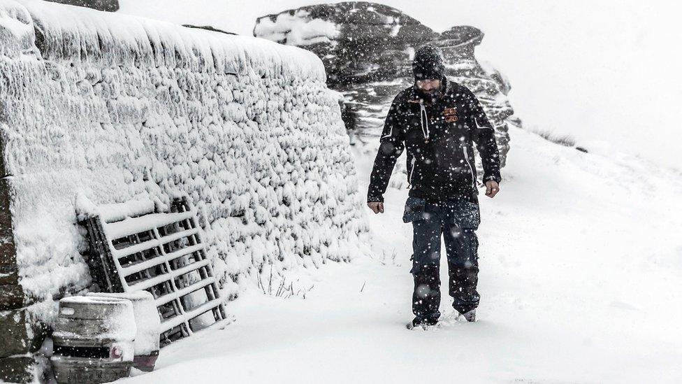 A man walks in snowy conditions at the Tan Hill Inn in North Yorkshire