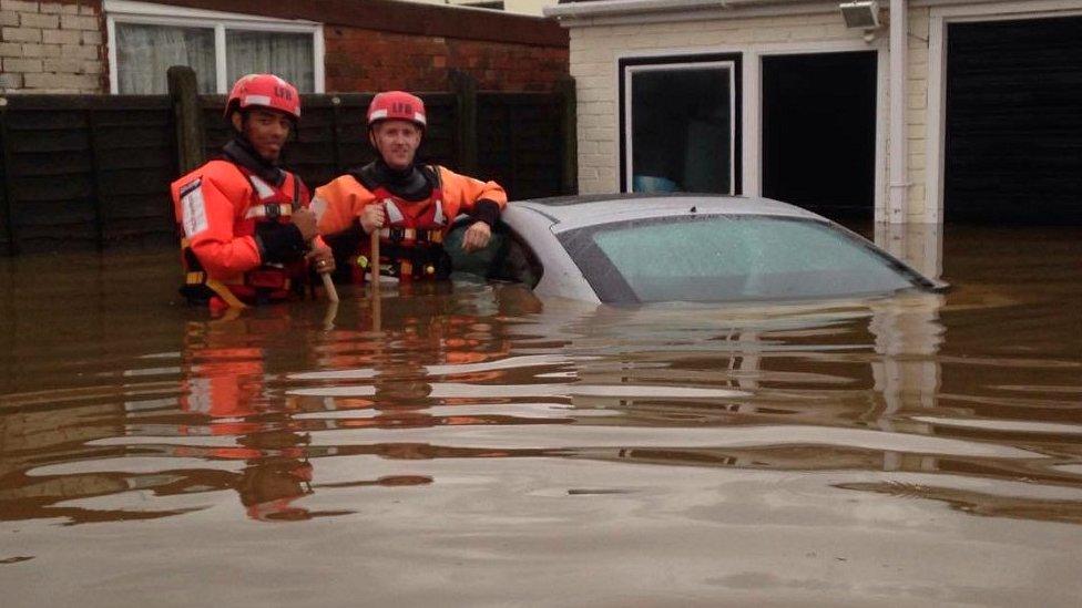 Fire rescue crew beside submerged car in Romford