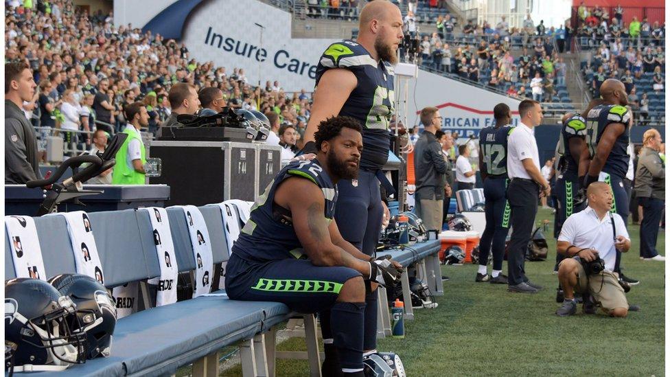 Picture of Michael Bennett sitting during the national anthem.