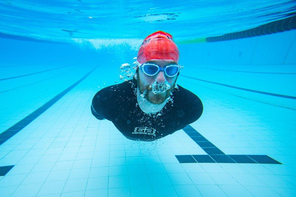 A swimmer glides underwater