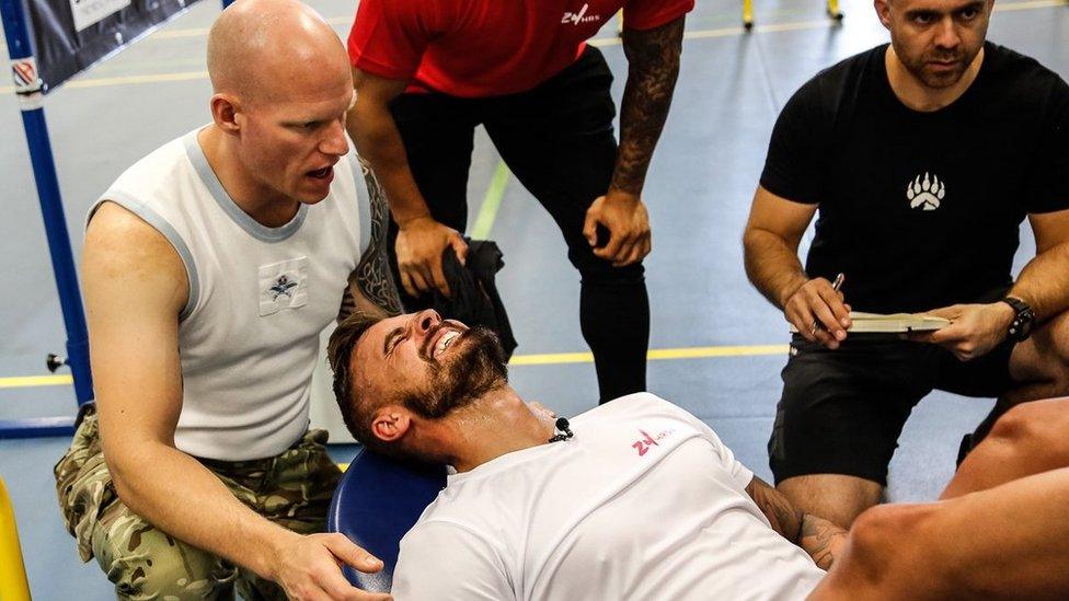 Gritted teeth: Josh Llewellyn-Jones leg presses 170kg surrounded by supporters