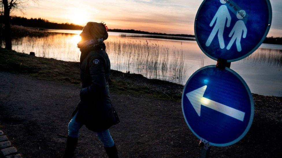 A woman walks on path in Copenhagen where a sign shows that a one-way system is in place