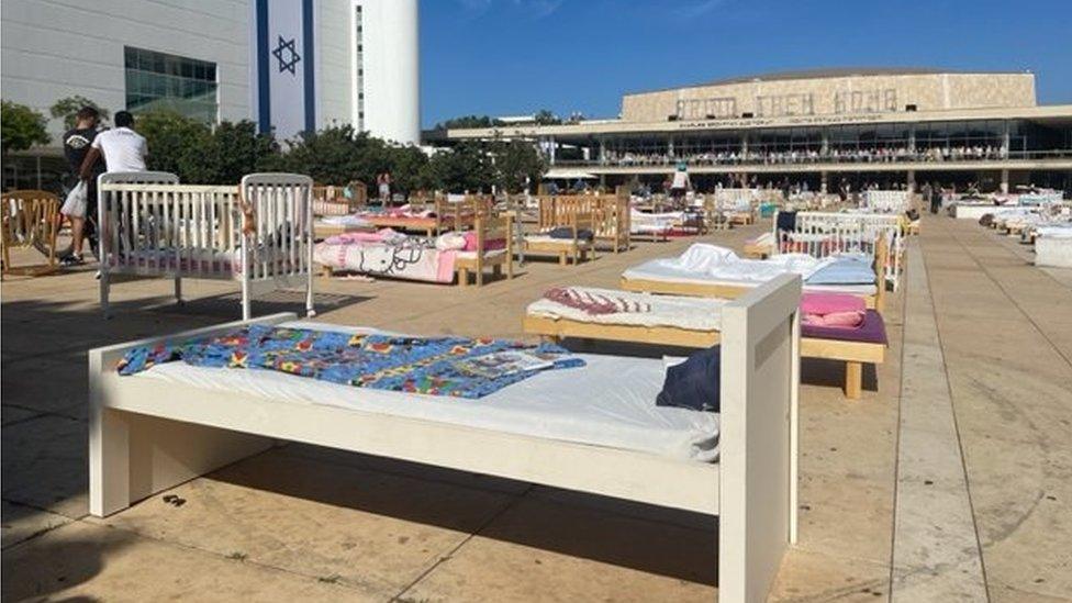 Beds in Habima Square as people gather for a candlelit vigil