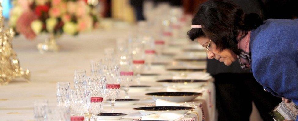 File pic of a visitor inspecting a dinner table at the presidential palace in 2008