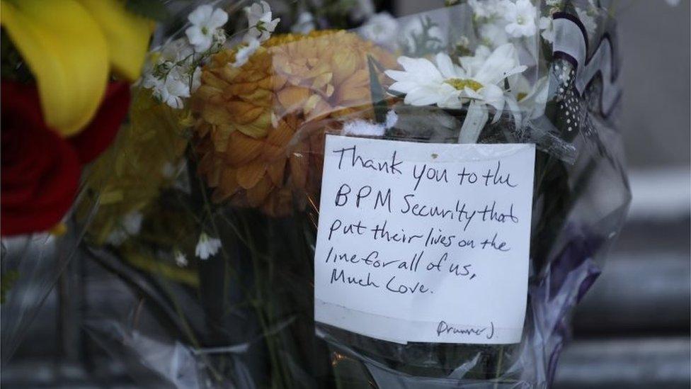 A handwritten note thanking the security guards at the BPM electronic festival, of whom there were several killed in early morning gunfire, is attached to flowers left at a barrier blocking the entrance to the Blue Parrot club, in Playa del Carmen, Mexico, Monday, Jan. 16, 2017.